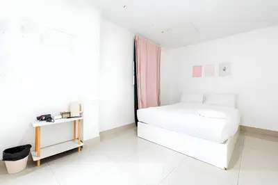 a white bedroom with a bed and a table at Oh My Nap Sukhumvit Soi 3 - คลองเตยเหนือ in Makkasan