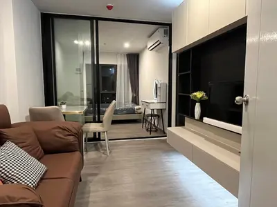 a living room with a couch and a dining room at Wutthakat high-rise exterior view room in Bangkok
