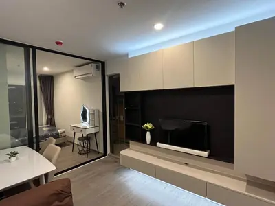 a living room with a large flat screen tv at Wutthakat high-rise exterior view room in Bangkok