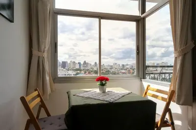 a table with a vase of flowers on it in front of a window at BTS skytrain Phra Khanong Happy Place 1bedroom with office set in Bangkok