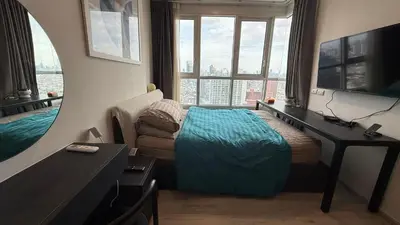 a bedroom with a bed and a desk and a mirror at Lovely home 2 in Ban Na Song