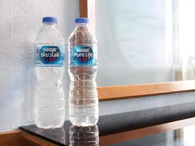 two bottles of water are sitting on a shelf at Wish Inn Chidlom - Ratchadamri Bangkok in Pratunam