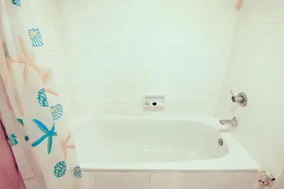 a bathroom with a shower with a white tub at Wish Inn Chidlom - Ratchadamri Bangkok in Pratunam