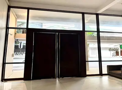 a black door in a room with windows at Wish Inn Silom - Decho Bangkok City in Bang Rak