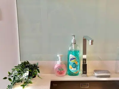 a sink with two bottles of soap and a mirror at Cozy City BTS Nana | Pool, Sauna & Gym 38th Floor in Makkasan