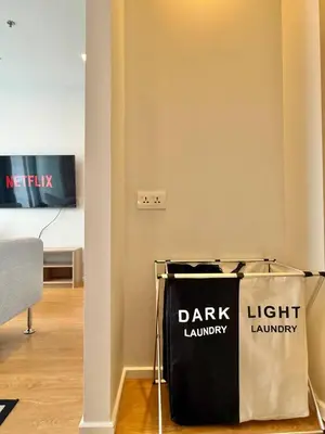 a dark laundry bag sitting on the floor in a room at Cozy City BTS Nana | Pool, Sauna & Gym 38th Floor in Makkasan