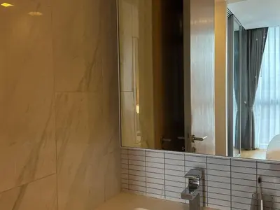 a bathroom with a large mirror and a sink at Cozy City BTS Nana | Pool, Sauna & Gym 38th Floor in Makkasan