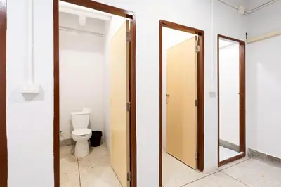a bathroom with a toilet and a mirror at xx Mitr inn Khaosan ถนนตะนาว in Bangkok