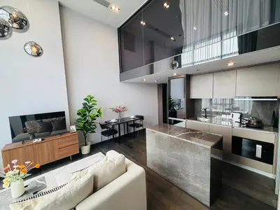 a living room with a couch and a kitchen at m51 \u5e02\u4e2d\u5fc3\u5962\u534e\u516c\u5bd3 \u4e34\u8fd1\u6377\u8fd0 \u4e91\u7aef\u6cf3\u6c60 \u9ad8\u7a7a\u5168\u666f\u5065\u8eab\u623f \u9ad8\u901f\u7f51\u7edc in Bangkok