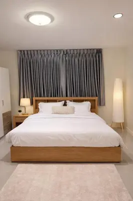 a bedroom with a large white bed in front of a window at 166 Living in Bangkok