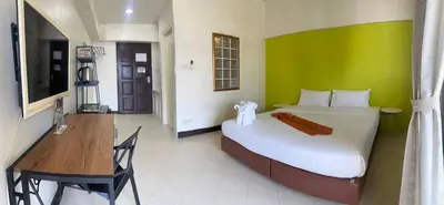 a bedroom with a bed with a green wall at Private Apartment in city center and near BTS in Bangkok