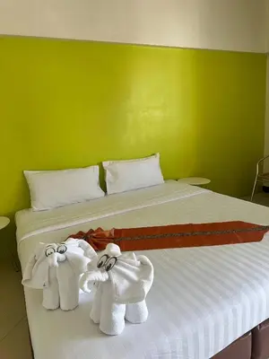 two towels on a bed with a green wall at Private Apartment in city center and near BTS in Bangkok