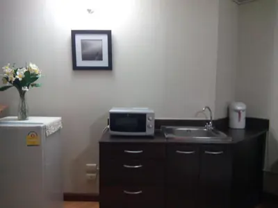 a kitchen with a sink and a microwave and a refrigerator at Asia Don Mueang Bangkok Condominium in Nonthaburi
