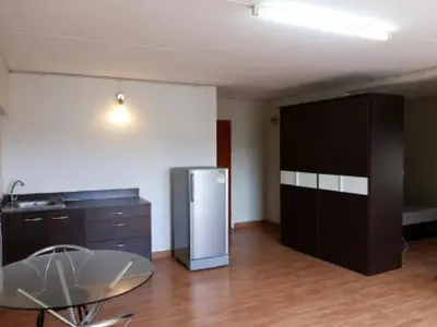 a kitchen with a table and a refrigerator in a room at Asia Don Mueang Bangkok Condominium in Nonthaburi