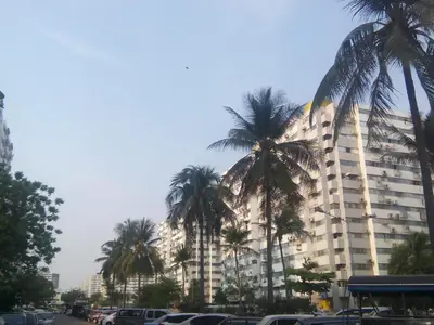a large building with palm trees in front of it at Asia Don Mueang Bangkok Condominium in Nonthaburi