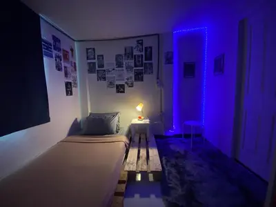 a small room with a bed and a blue light at High Friend Hostel in Phra Khanong