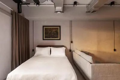 a bedroom with a bed and a couch at The District Hostel Ekkamai in Sathani Khlong Tan