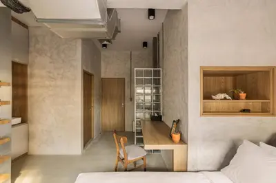a bedroom with a bed and a desk and a chair at The District Hostel Ekkamai in Sathani Khlong Tan