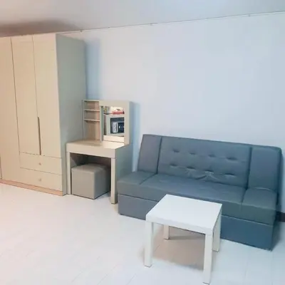 a living room with a blue couch and a table at Boontharika Place Cozy Room Popular Condo near IMPACT Muangthong in Thung Si Kan