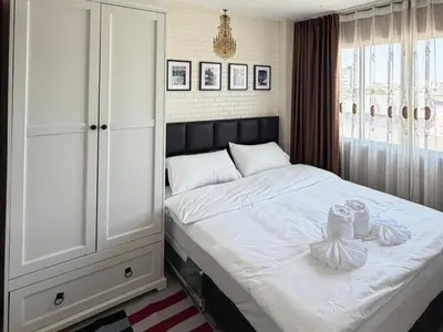 a bedroom with a white bed with two shoes on it at Stadium Area Stay Famous Thai Street Food in Bangkok