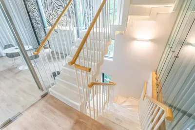 a staircase in a home with a white stair case at Heaven Sukhumvit 62Villa in Bangkok