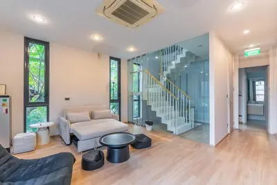 a living room with a couch and a stair case at Heaven Sukhumvit 62Villa in Bangkok