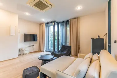 a living room with a couch and a tv at Heaven Sukhumvit 62Villa in Bangkok