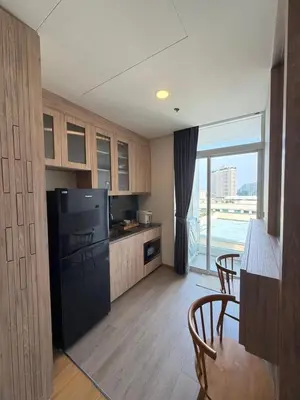 a kitchen with a black refrigerator and a table with chairs at Sky Luxury Near BTS Ekkamai pool gym Netflix in Khlong Toei