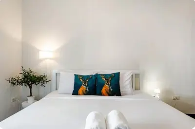 a white bed with two pillows on top of it at Baan Surawong 390 Heritag house in Chinatown