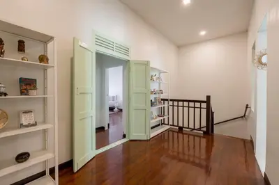 a room with a staircase and a hallway with green doors at Baan Surawong 390 Heritag house in Chinatown