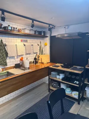 a kitchen with a counter and chairs in a room at Sleepben in Bangkok