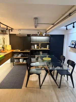 a dining room with a glass table and chairs at Sleepben in Bangkok