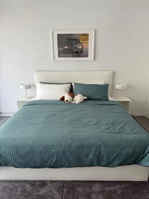 a dog laying on top of a bed at Sleepben in Bangkok