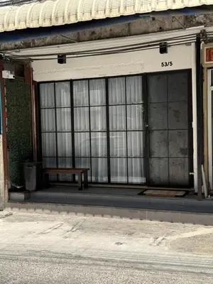 a bench sitting in front of a building with windows at Sleepben in Bangkok