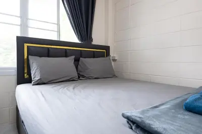 a bed with white sheets and pillows next to a window at ดอนเมือง 307 Near DMK Airport BTS Wat PhraSi in Bang Khen