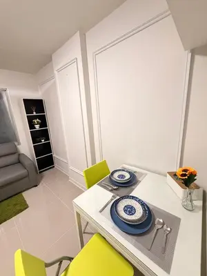 a dining room with a table and yellow chairs at Best Value Condo Lumpini Rajamangala in Sathani Khlong Tan