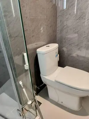 a bathroom with a toilet and a glass shower at Modern 2BR-3 Mins Walking Distance to BTS Thonglor in Bangkok