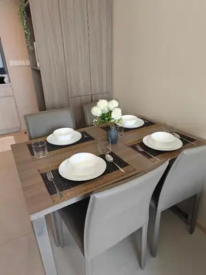 a dining room table with plates and flowers on it at Modern 2BR-3 Mins Walking Distance to BTS Thonglor in Bangkok