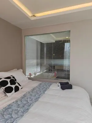 a bedroom with two beds and a large window at Modern 2BR-3 Mins Walking Distance to BTS Thonglor in Bangkok