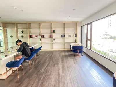 a man sitting at a bar in a room with chairs at Long-Stay High Floor Apartment, Bangna, Near BTS, Malls in Bang Chak