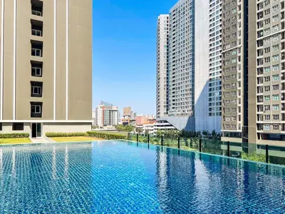 a large swimming pool in a city with tall buildings at Long-Stay High Floor Apartment, Bangna, Near BTS, Malls in Bang Chak