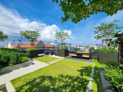a view of a park with a bench and grass at Quiet apartment with pool close to MRT station in Bangna