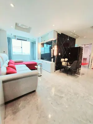 a large living room with a couch and a table at Charming 2-Bedroom Apartment in ON-NUT, Bangkok in Amphoe Phra Khanong