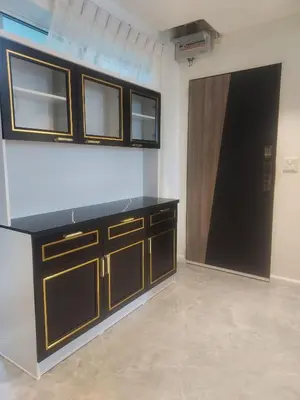 a kitchen with wooden cabinets and a black counter top at Charming 2-Bedroom Apartment in ON-NUT, Bangkok in Amphoe Phra Khanong