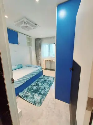 a room with two beds and a blue door at Charming 2-Bedroom Apartment in ON-NUT, Bangkok in Amphoe Phra Khanong