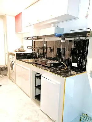 a kitchen with a sink and a stove at Charming 2-Bedroom Apartment in ON-NUT, Bangkok in Amphoe Phra Khanong