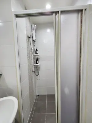 a bathroom with a shower with a toilet and a sink at Homely Condo Minimal Style Near BTS Silom line in Bang Khun Thian