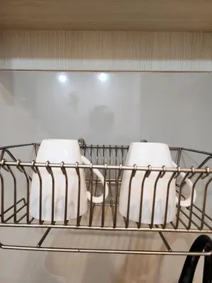a shelf with three white dishes on it at Homely Condo Minimal Style Near BTS Silom line in Bang Khun Thian