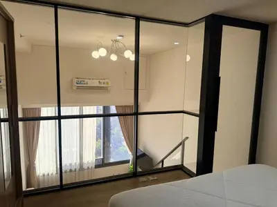 a bedroom with a large glass window and a bed at 5 Min walk to BTS Onnut Duplex Loft At Sukhumvit in Amphoe Phra Khanong