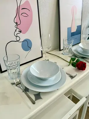 a table with plates and glasses on a table at 5 Min walk to BTS Onnut Duplex Loft At Sukhumvit in Amphoe Phra Khanong